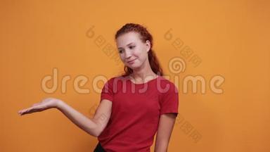 微笑的年轻女士穿着红色衬衫，把空间放在一边，把手放在腰部